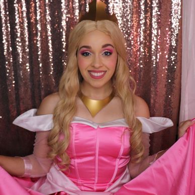 Aurora, sleeping beauty birthday character for birthday parties posing in her pink ball gown 