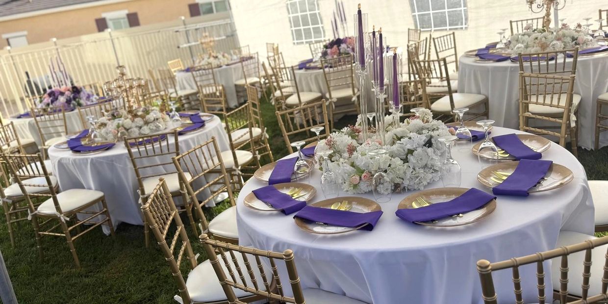 Elegant outdoor tables with gold chairs, white linens, and purple accents.