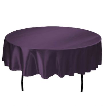 Round table with a dark purple tablecloth.