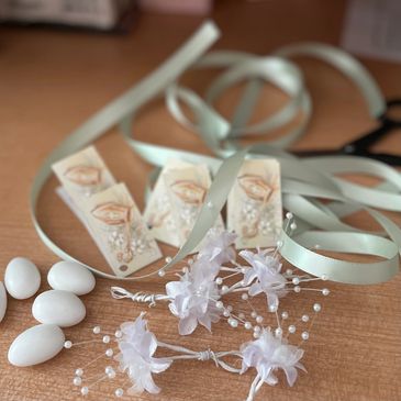 Confirmation tags with sage green ribbons, white babies breath flowers, white almonds and scissors