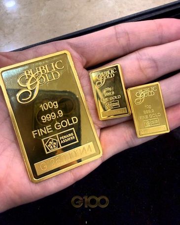 Three gold bars of different weights in a hand.