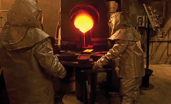 Workers pouring molten metal in a foundry.