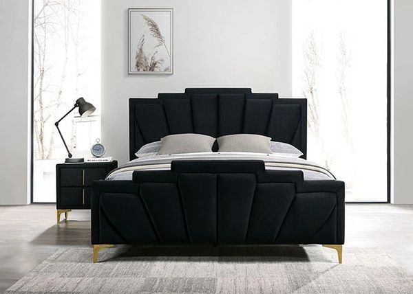 Modern black upholstered bed with gold legs.