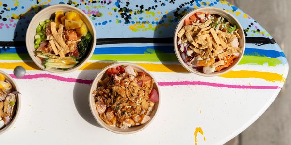 poke bowls in a white bowl on a surfboard table