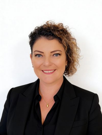 Professional woman with curly hair and a black blazer.