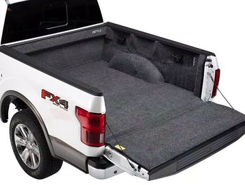 Carpet-lined truck bed with tailgate down in a white pickup.