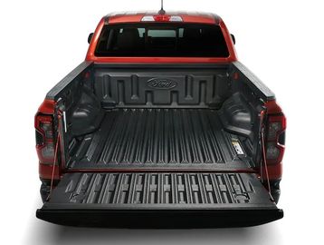 Open bed of a red Ford pickup truck showing its spacious cargo area.
