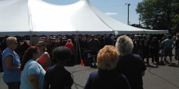 People gathered outside a large white event tent.