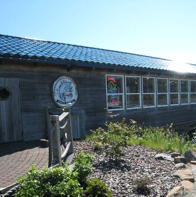 A restaurant with a sign and windows.