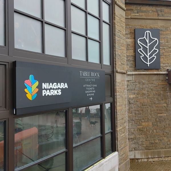 Niagara Parks Table Rock Centre entrance with signage and reflections.