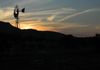 Windmill on 12 with sun setting beyond adjacient NM State Land.