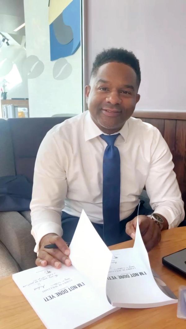 Author Cobby M. Williams signing copies of I'm Not Done Yet