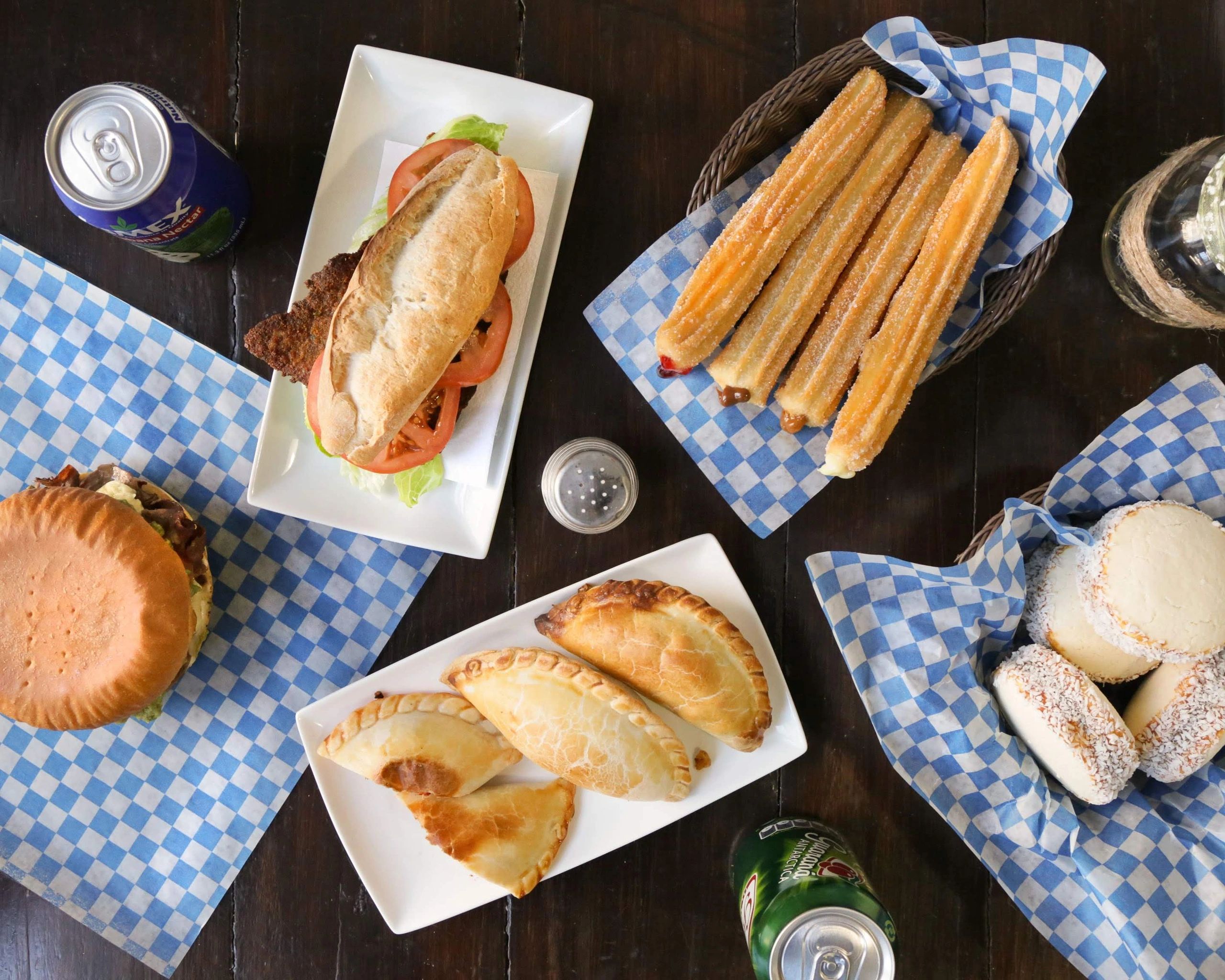 Variété d'aliments se trouvant dans le menu de Che Churros&Empanadas. Churros, empanadas, sandwichs