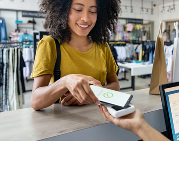 Woman making a contactless payment with her phone at a store counter.