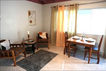 Image of a dining area of a hotel room. Two chairs also appear in the image.