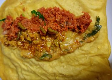 Close-up of an Indian dish with chutney and curry on a dalpuri.