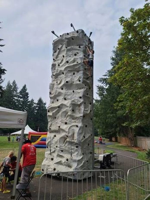 Large gray climbing wall column with adult/child participants
