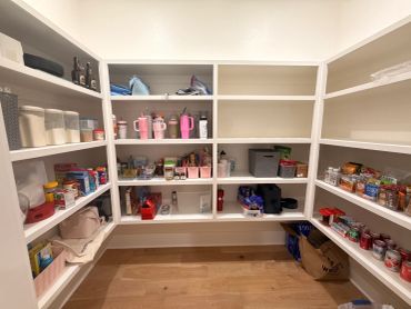 Organized pantry with shelves and various food items and containers.