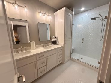 Modern bathroom with double sink and glass shower.