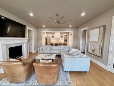 Modern living room with beige and brown furniture and an open kitchen.