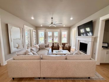Modern living room with beige sofa and leather chairs.