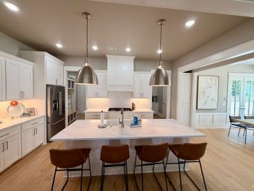 Modern kitchen with white cabinetry and pendant lighting.