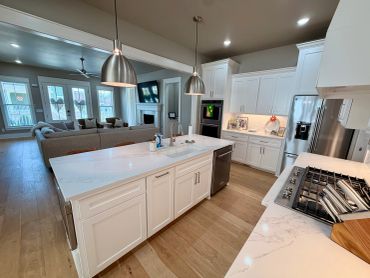 Modern kitchen with white cabinetry and stainless steel appliances.