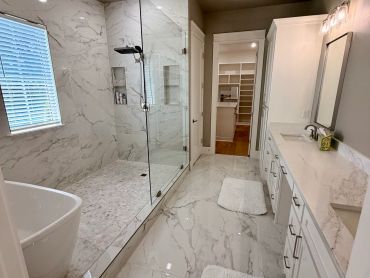 Modern bathroom with marble finish and walk-in shower.