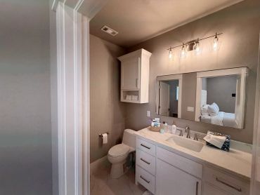 Modern bathroom with white cabinetry and warm lighting.