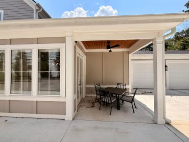 Covered patio with outdoor dining set and ceiling fan.