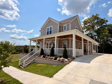 A modern house with a spacious porch and a clear blue sky.