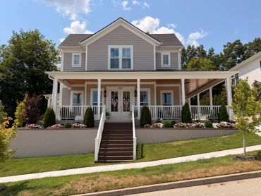 A two-story house with a front porch and stairs.