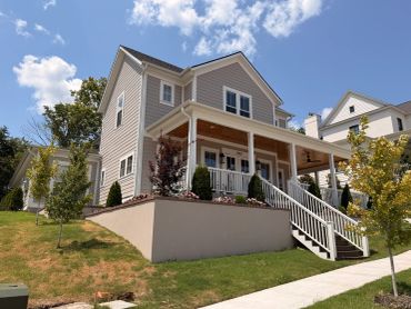 Two-story house with porch and stairs.