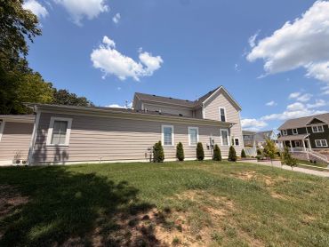 Suburban house with clear blue sky and scattered clouds.