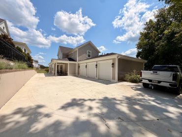 Modern suburban house with three-car garage and truck.