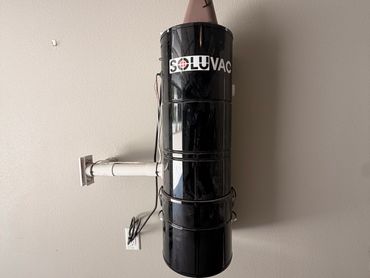 Black Soluvac device mounted on a wall.