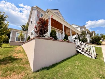 Upward view of a house with porch and stairs.