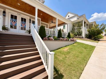 Modern houses with wooden stairs and patriotic door decorations.