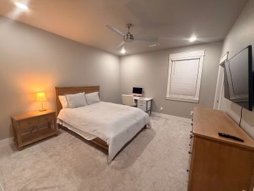 Cozy bedroom with neutral tones and wooden furniture.