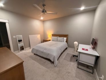 Cozy bedroom with bed, desk, and mirror.