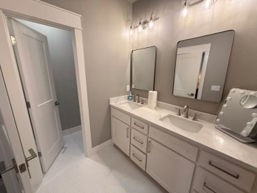 Modern bathroom with double sinks and mirrors.