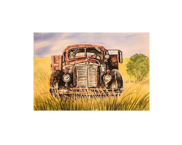 A rusted, red truck sits in a field