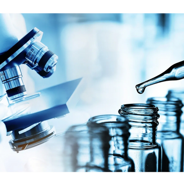 Scientist preparing a microscope slide with a pipette and vials in a lab.
