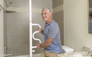 man using Stander Security Pole with Curve Grab bar in bathroom