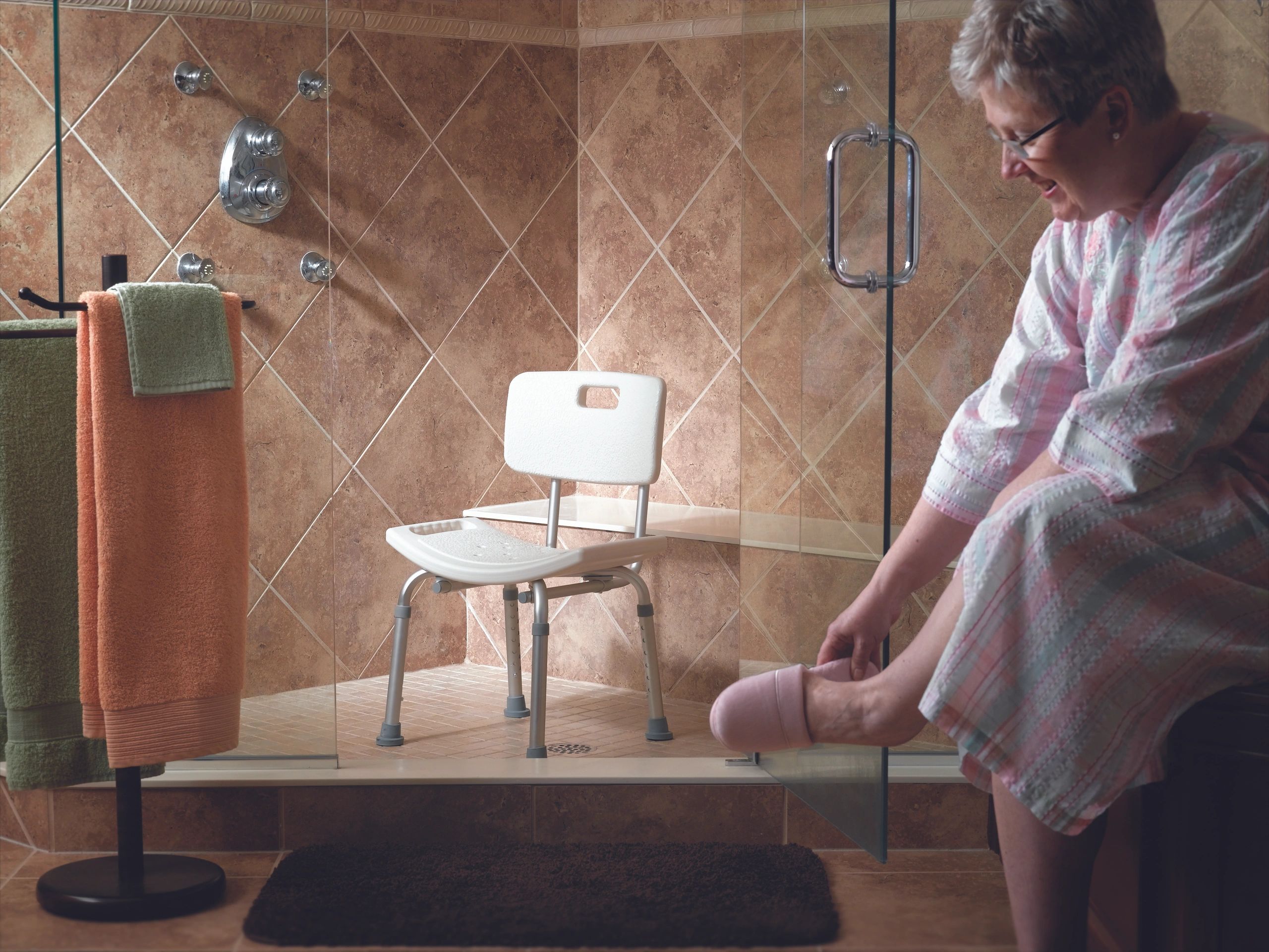 woman in bathroom with shower chair in shower