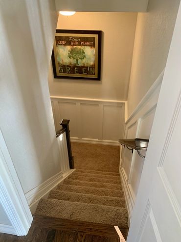 Stair update opening wall for open rail with Newell post, with picture frame trim, and new paint.