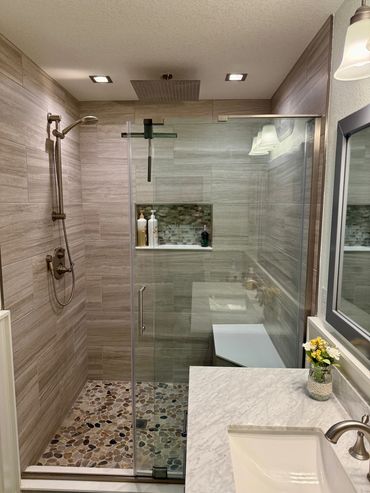 Bathroom remodel with bend seat, rain shower, glass cubby, poured shower pan, frameless shower door.