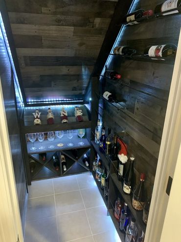 Home remodel basement finish with under stairs wine closet. Tile flooring, accent lighting, Parker