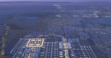 Aerial view of a large, illuminated airport layout at dusk or dawn.