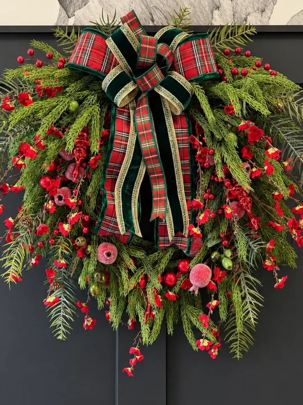 Festive Christmas wreath with plaid bow and red berries.